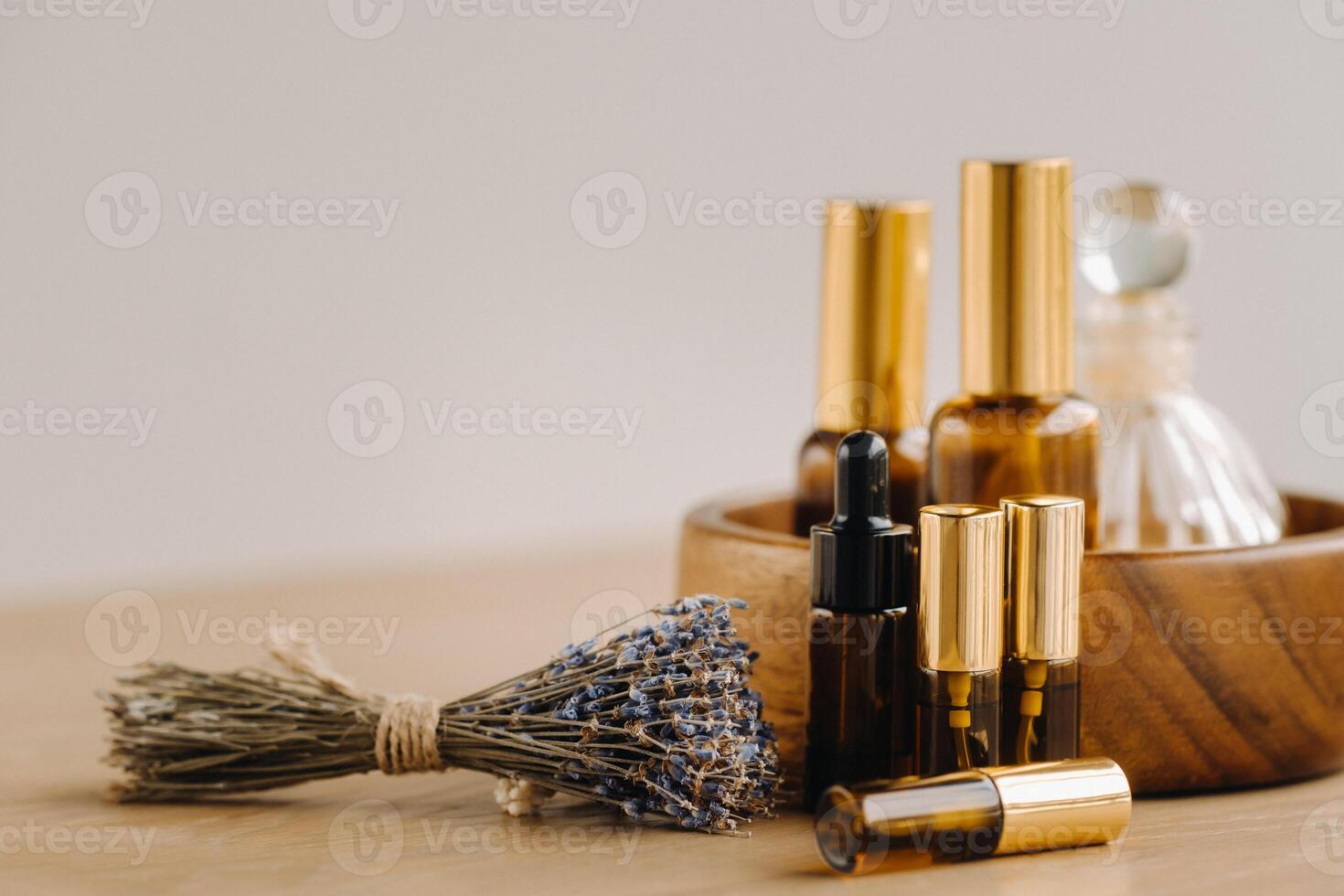 Essential oil in bottles with lavender fragrance, lying on a wooden surface photo