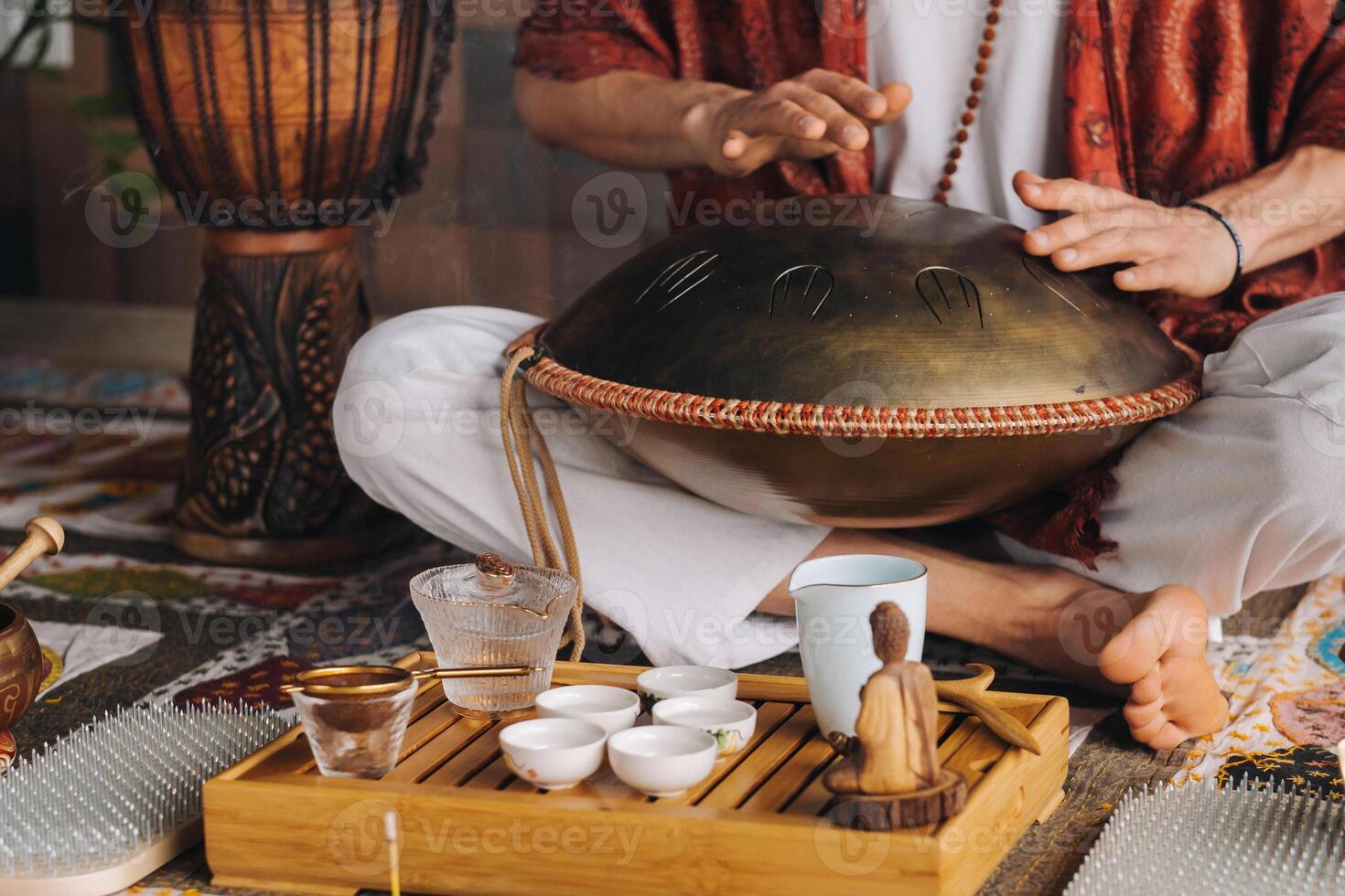 de cerca de un del hombre mano jugando un moderno musical instrumento - el Orión lengua tambor durante el té ceremonia foto