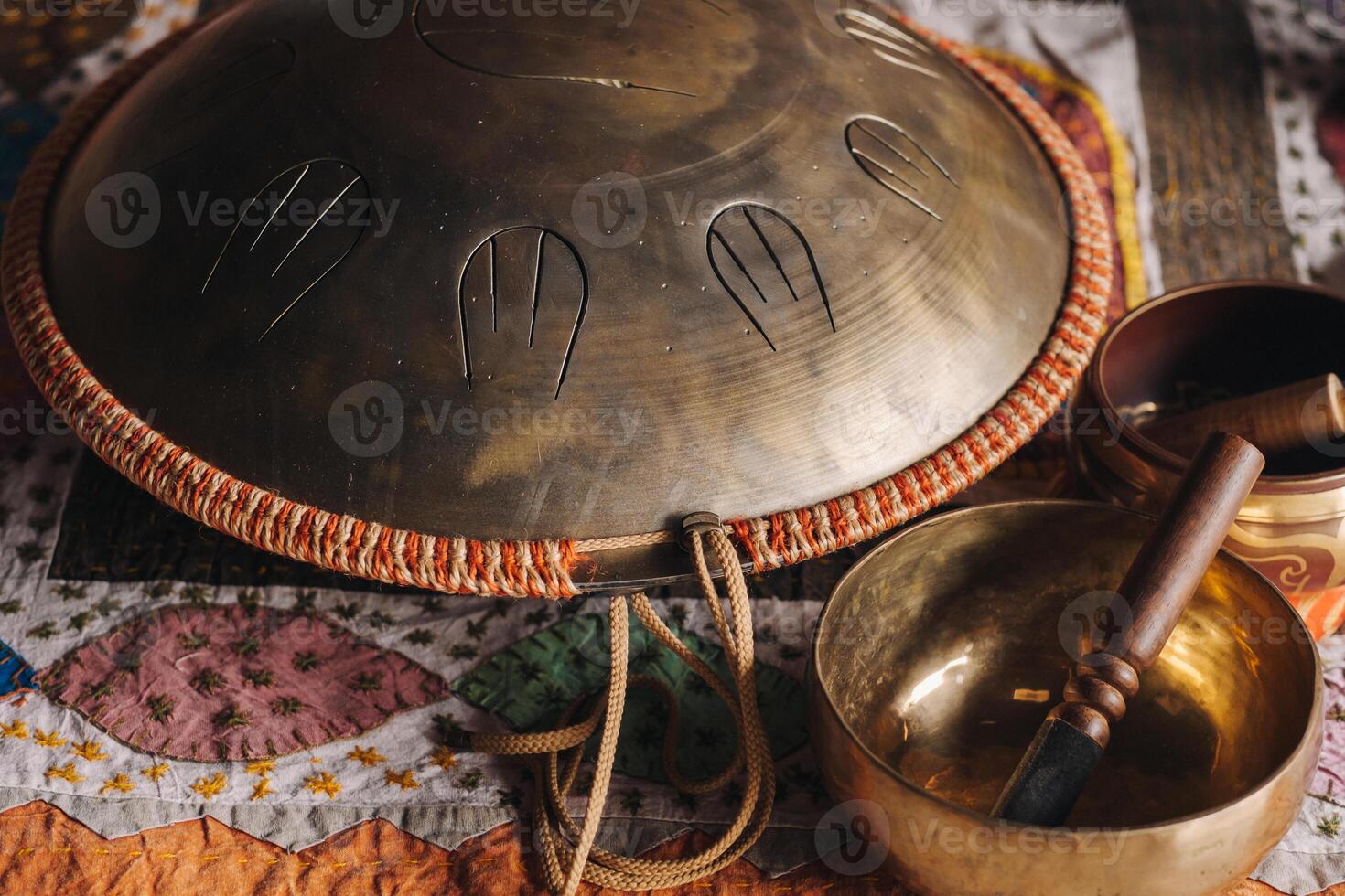 Tongue drum and Tibetan bowls lying on the carpet photo