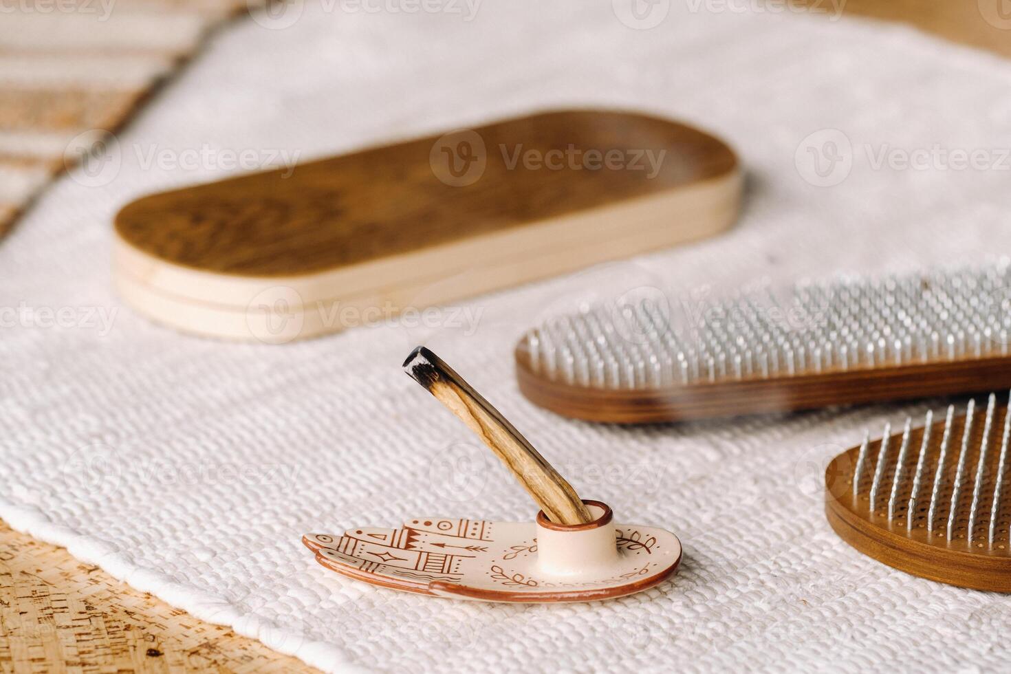 A smoking Palo Santo stick and boards with nails for yoga classes photo