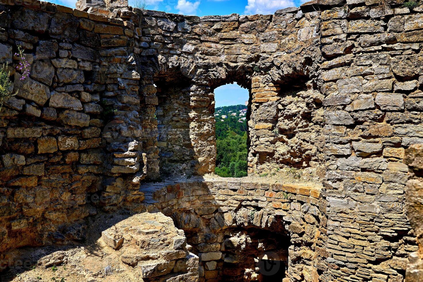 Loophole window in the old wall of the ancient fortress photo