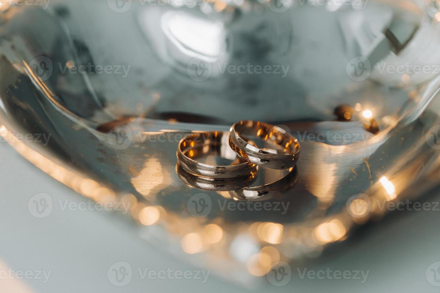 diseñador Boda anillos acostado en el superficie. dos Boda anillos foto