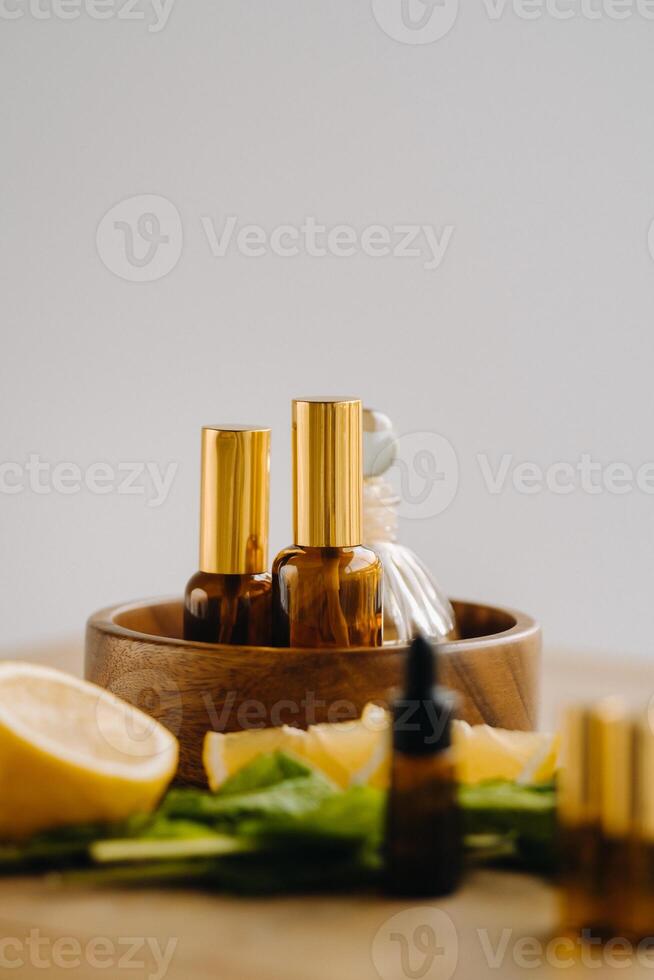 Essential oil in bottles with lemon and mint fragrance lying on a wooden surface photo