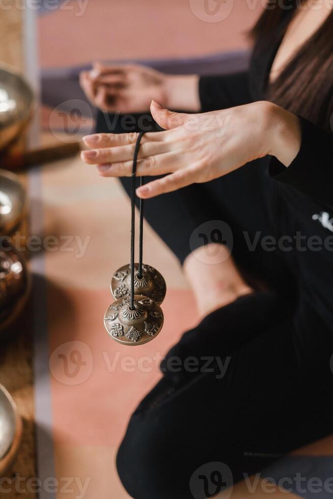 Close-up of a woman's hand holding Tibetan bells for sound therapy. Tibetan cymbals photo