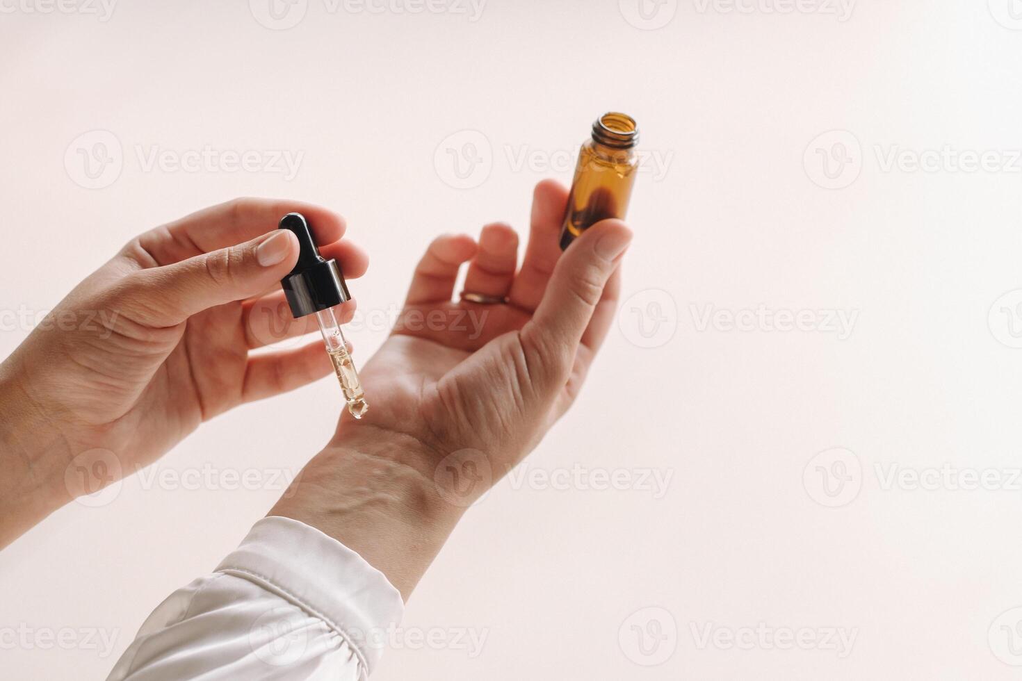 Close-up of a Woman's hands applying essential oil on her wrist indoors photo