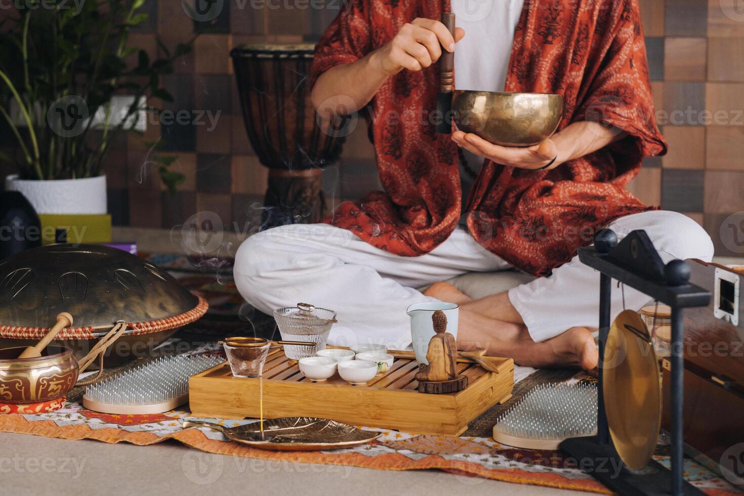Tibetan singing bowl in the hands of a man during a tea ceremony photo