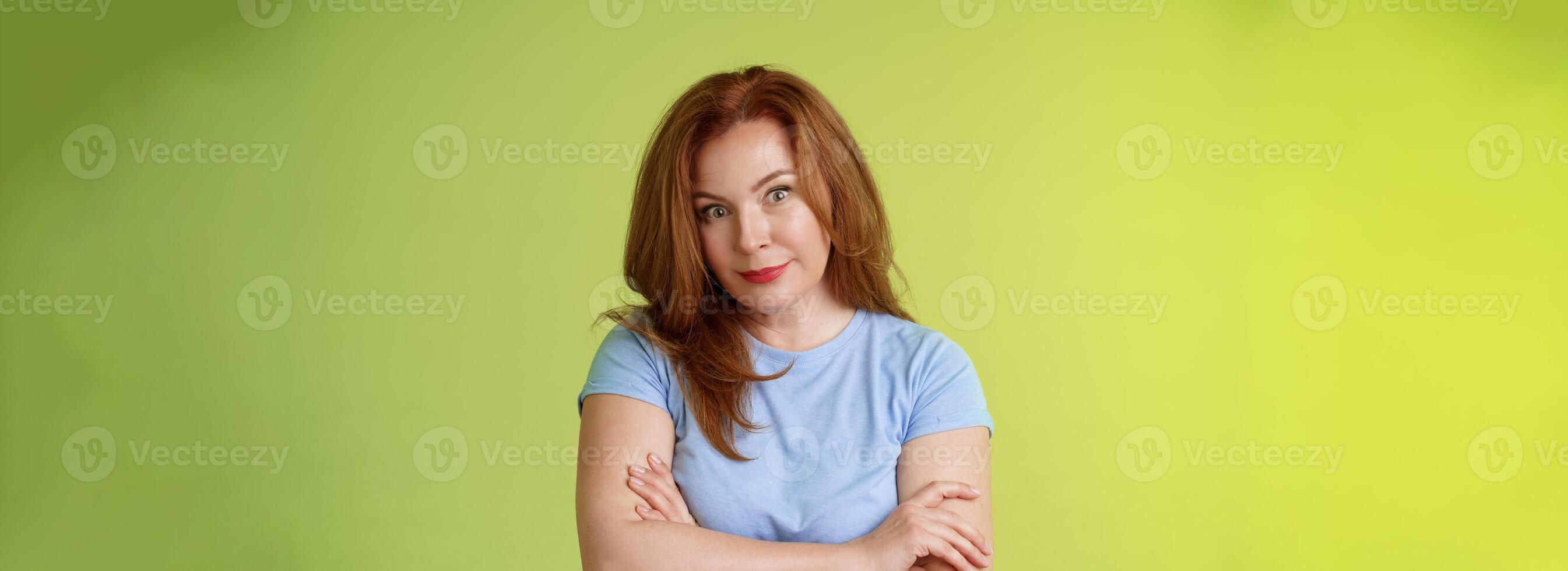Confused shocked redhead mother look serious worried puzzled cross arms chest self-soothing calming gesture stare camera perplexed frustrated bad son behaviour stand green background disappointed photo
