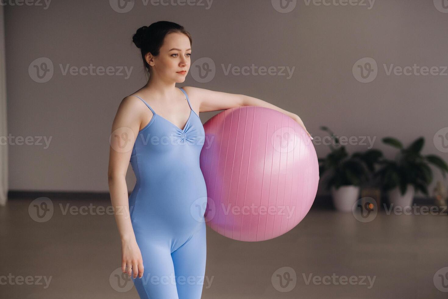 Pregnant woman during fitness classes with a fitball photo