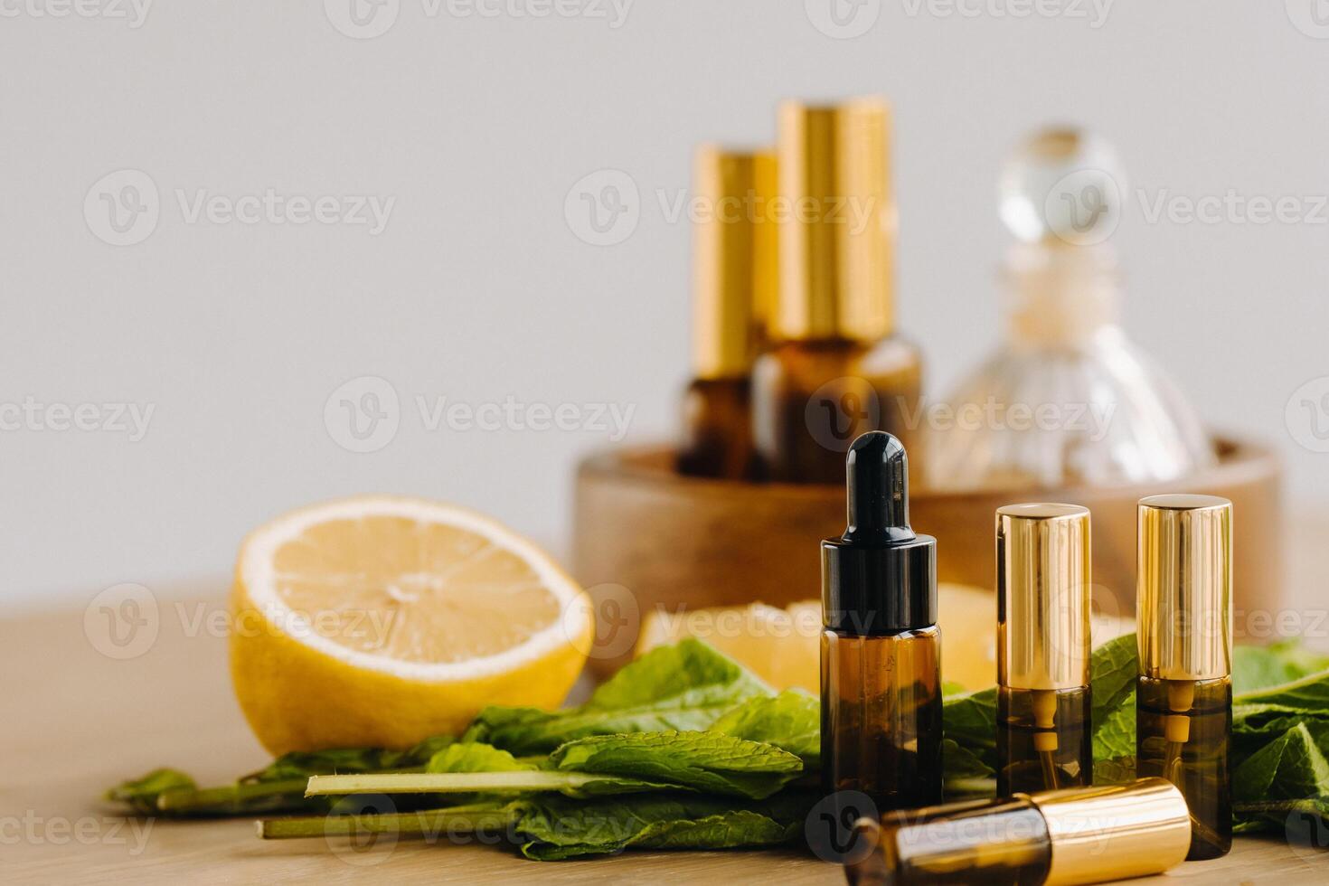 Essential oil in bottles with lemon and mint fragrance lying on a wooden surface photo