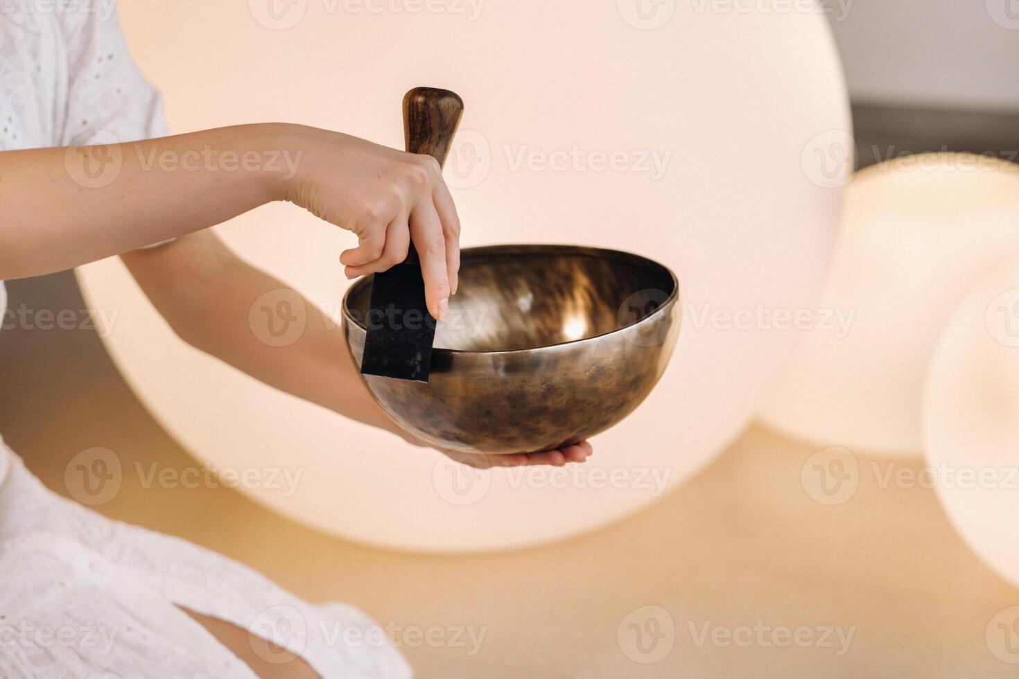 Close-up of a Tibetan singing bowl in your hands Translation of mantras transform your impure body, speech and mind into a pure exalted body, speech and mind of a Buddha photo