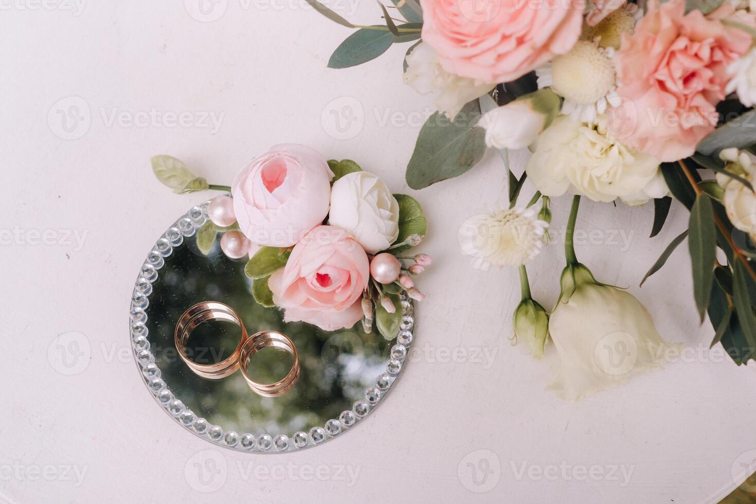 Designer wedding rings lying on the table for the ceremony and decor of roses. Two wedding rings photo