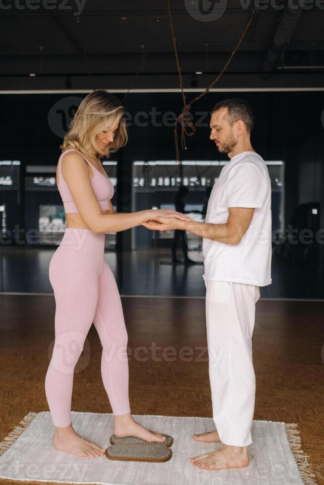 un hombre y un mujer hacer yoga en tableros con uñas en el gimnasio foto