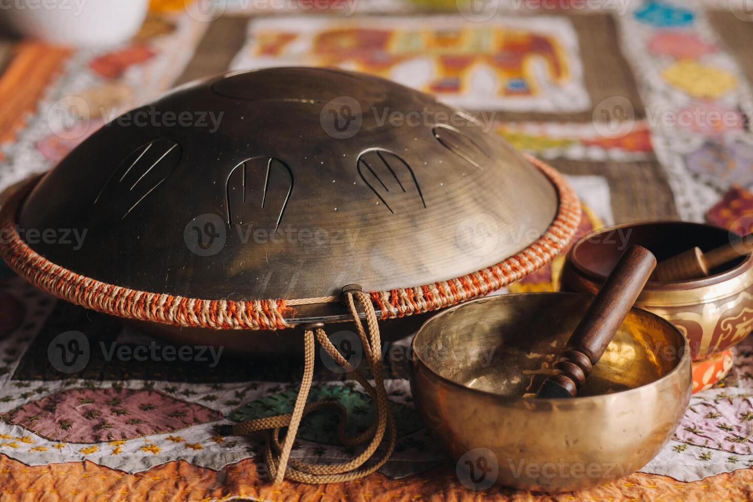 Tongue drum and Tibetan bowls lying on the carpet photo
