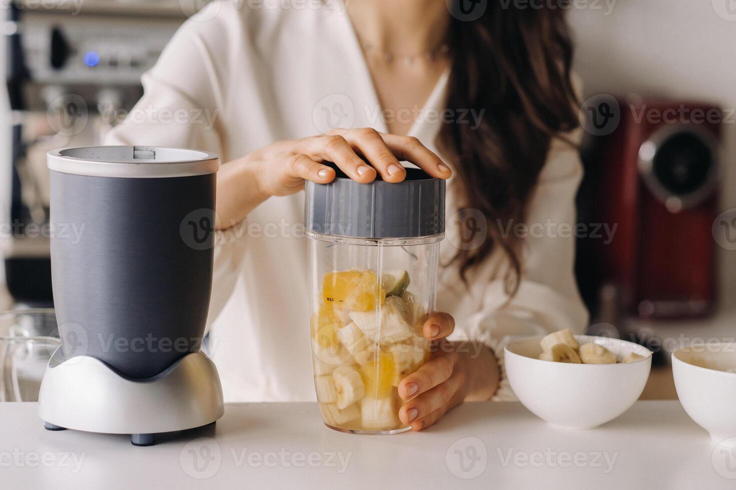 Close-up of the hands of a girl who makes a detox cocktail of fruit in the kitchen. Diet for weight loss photo