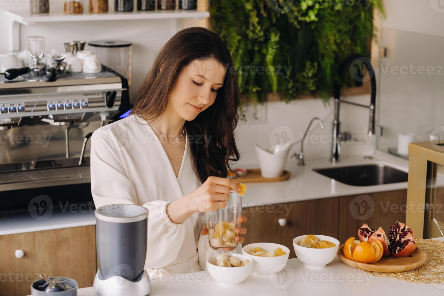 a girl makes a detox cocktail of fruit in the kitchen . Diet for weight loss photo