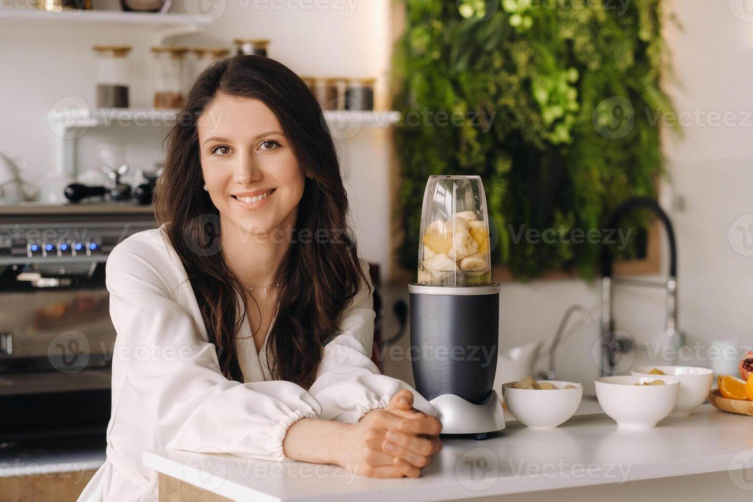 Portrait of a girl who makes a delicious fruit cocktail in the kitchen. Diet for weight loss photo