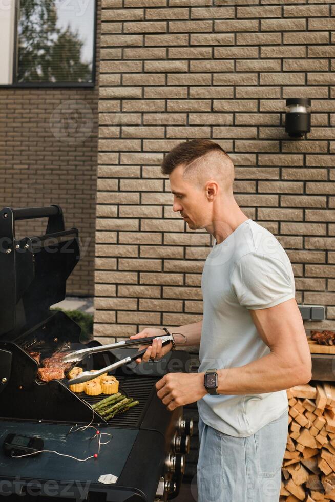 un hombre en el calle es Cocinando un filete en el parrilla a un parilla foto