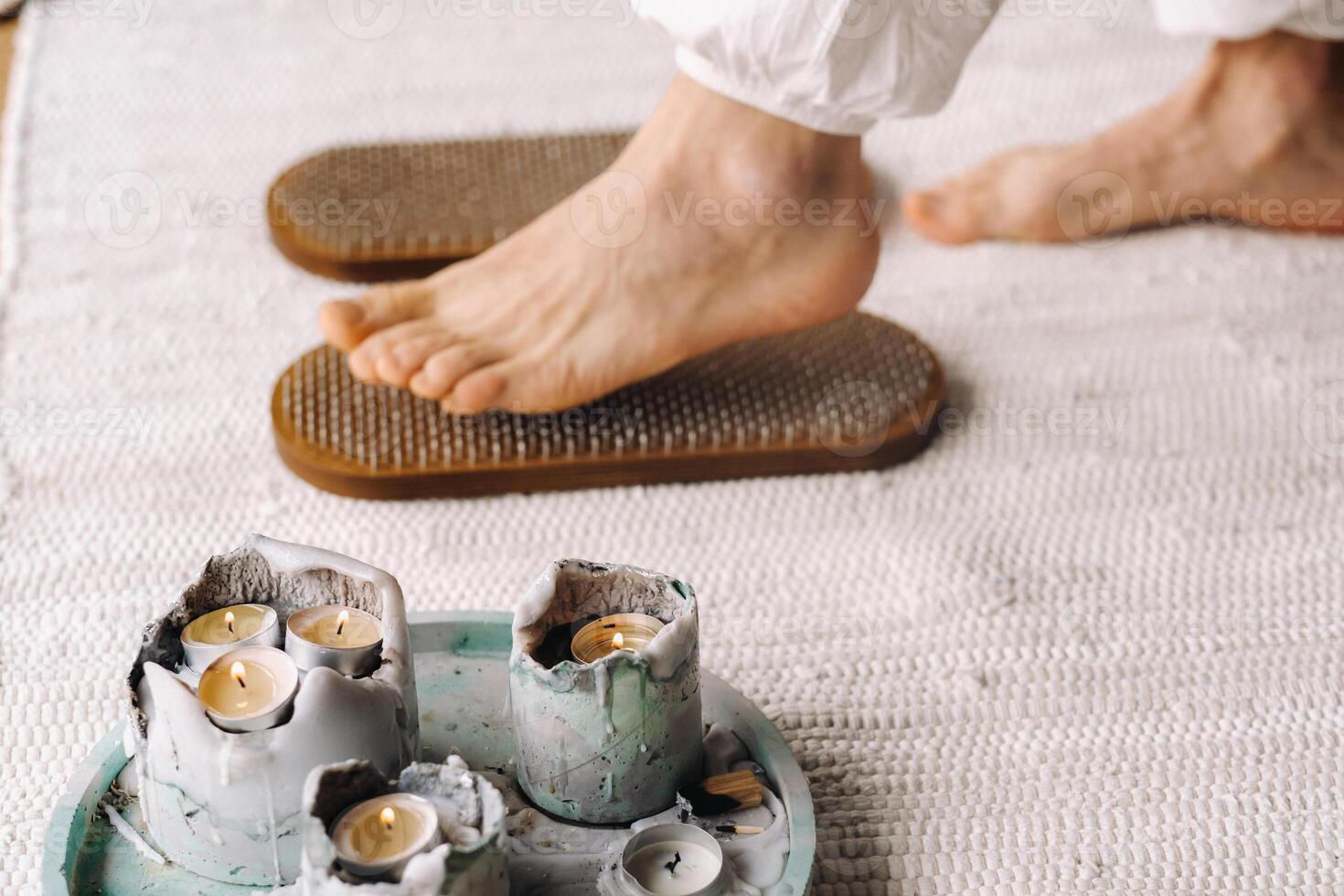 The man's feet are next to boards with nails. Yoga classes photo