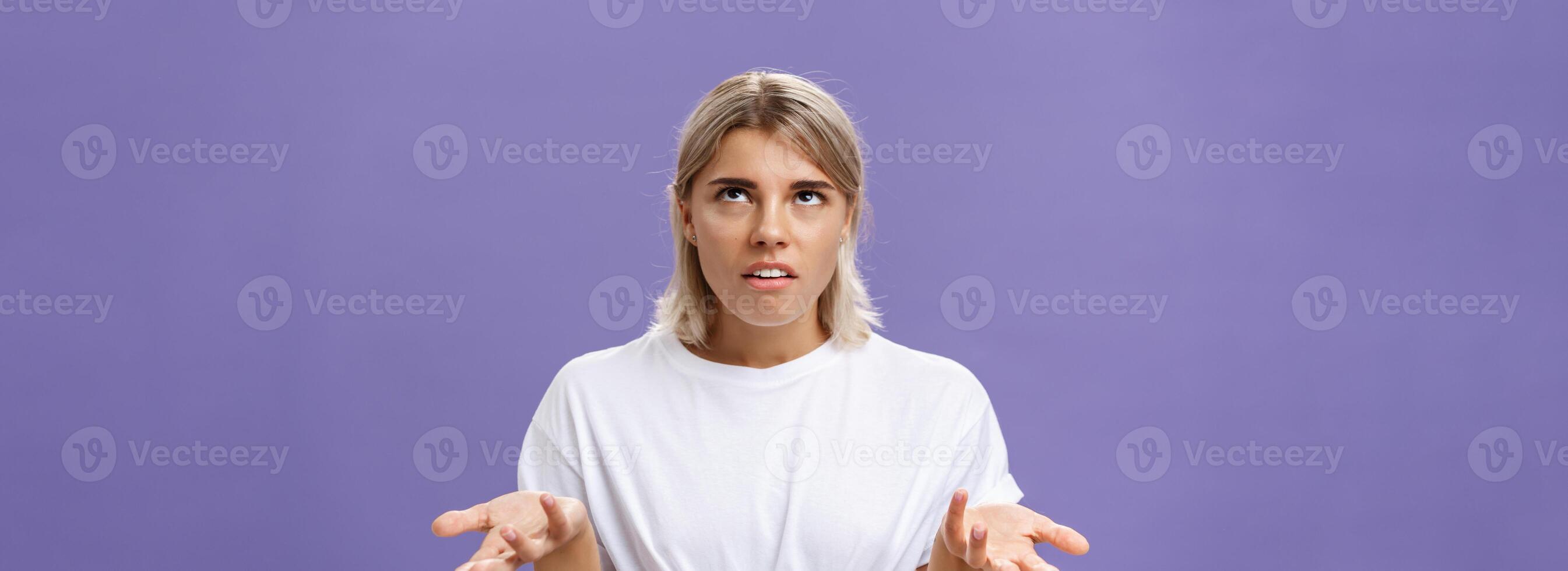 Nah I have no idea. Portrait of irritated bothered good-looking european woman with fair hair rolling eyes up with disappointed expression shrugging with hands raised in clueless gesture photo