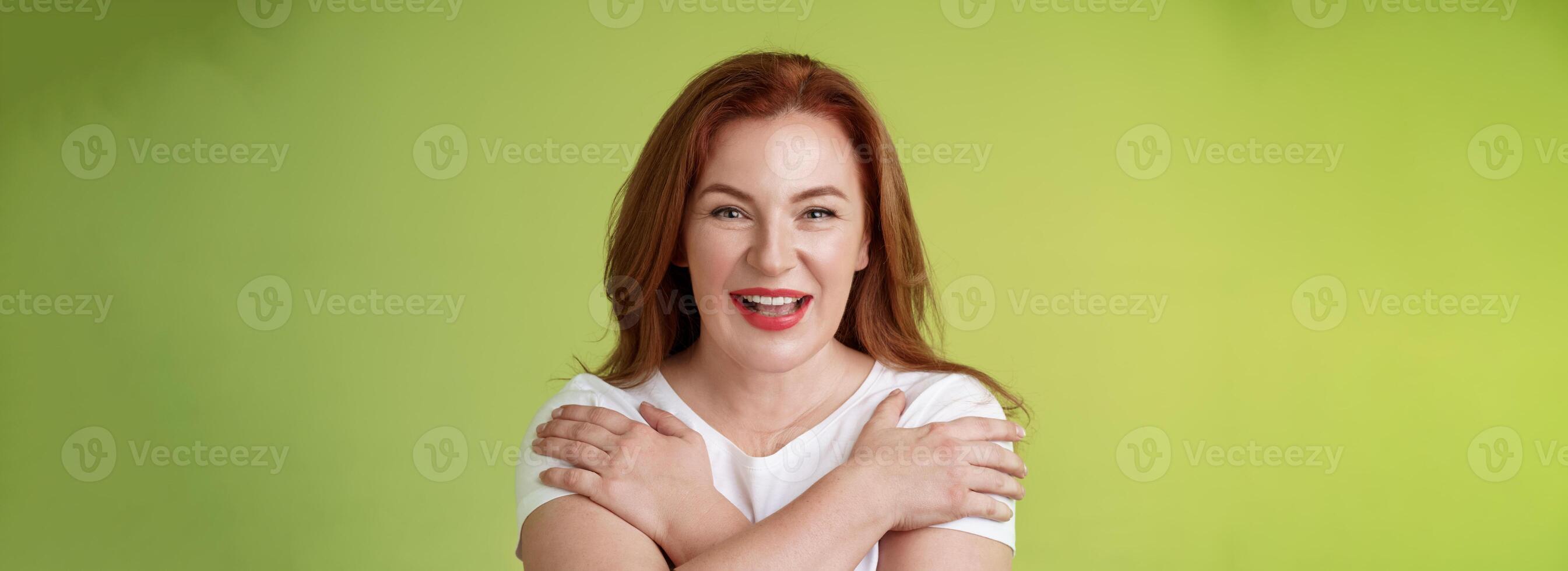 Cheerful charismatic happy good-looking redhead woman red lipstick cross hands chest smiling motivated excited having fun playful thrilled mood grinning enthusiastic standing green background photo