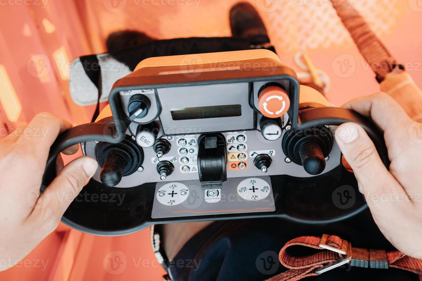 Remote control of a lifting car crane in the hands of a person. Panel with joysticks and buttons for controlling the telescopic bucket of the crane. photo