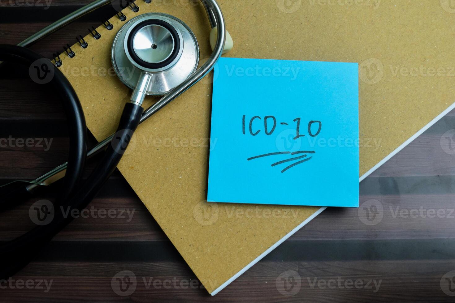 Concept of ICD-10 write on sticky notes with stethoscope isolated on Wooden Table. photo