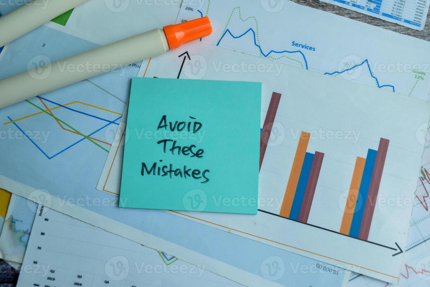 Concept of Avoid These Mistakes write on sticky notes isolated on Wooden Table. photo