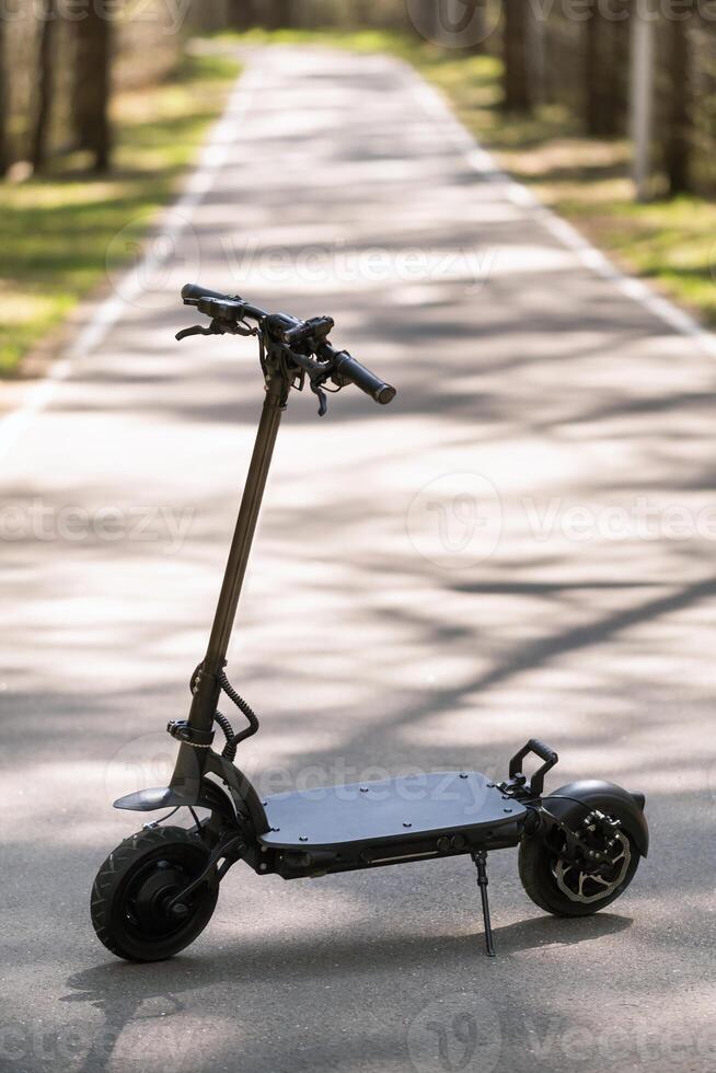 Black Electric scooter standing on the running board on the street photo