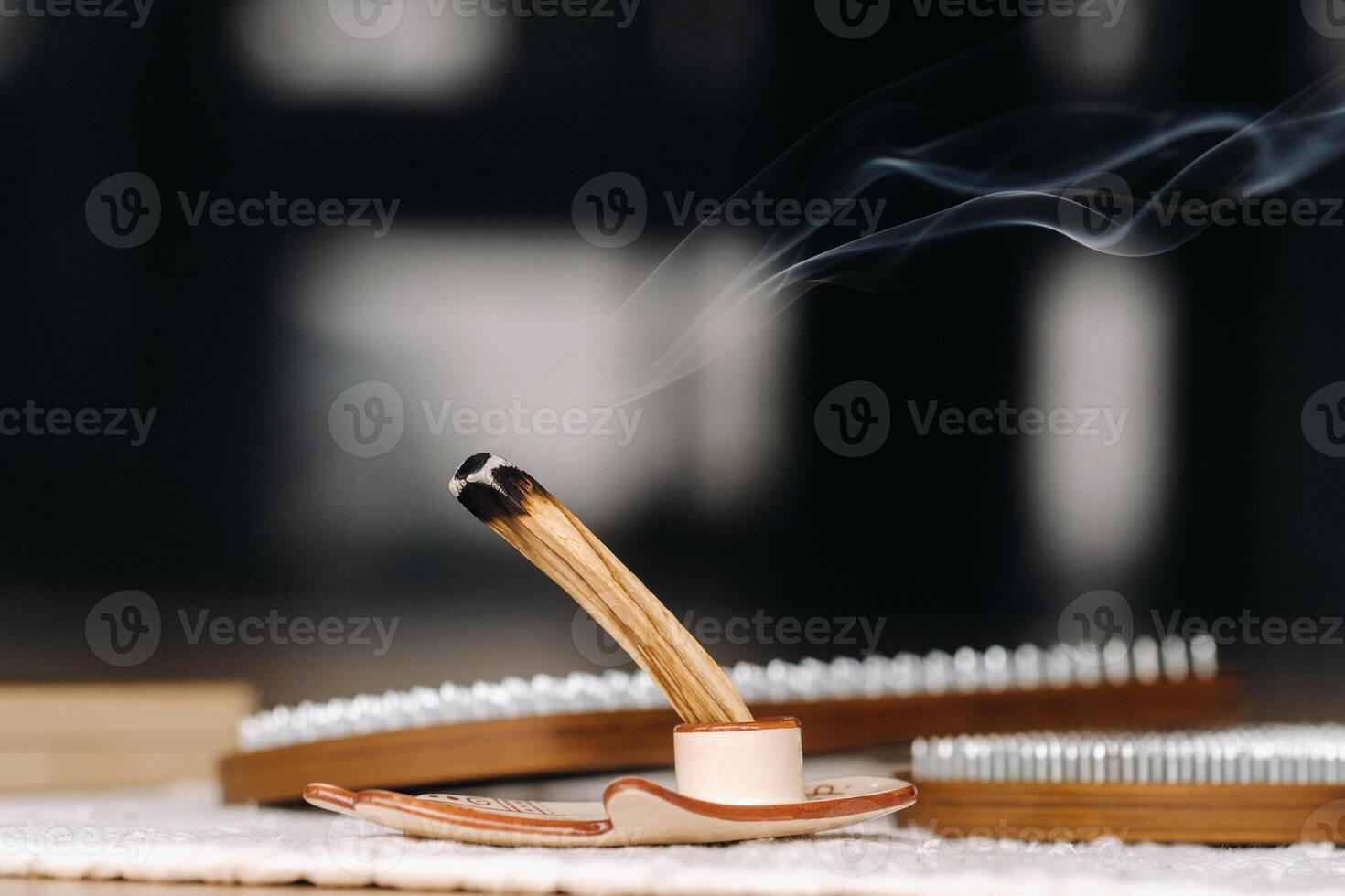 A smoking Palo Santo stick and boards with nails for yoga classes photo