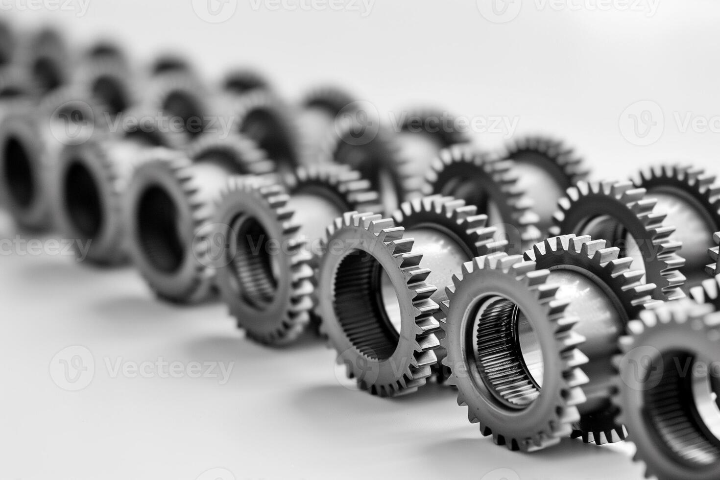 AI generated Black and white close up of a series of aligned metal gears showcasing concepts of teamwork, machinery, and precision engineering, with a depth of field effect photo