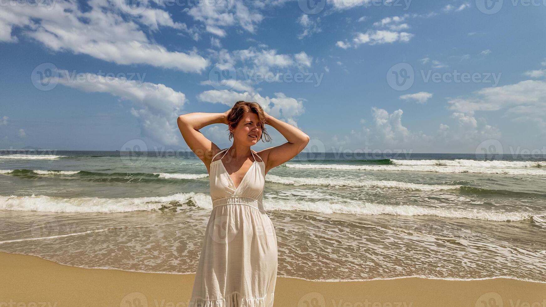 Carefree Woman Embraces Summer on Beach photo