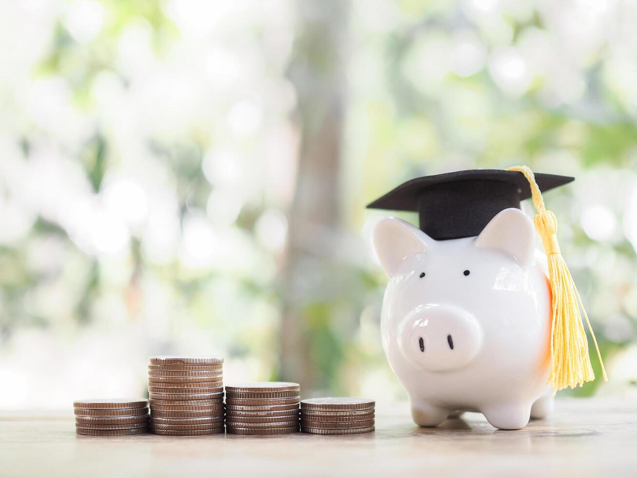 Piggy bank with graduation hat and stack of coins. The concept of saving money for education, student loan, scholarship, tuition fees in future photo