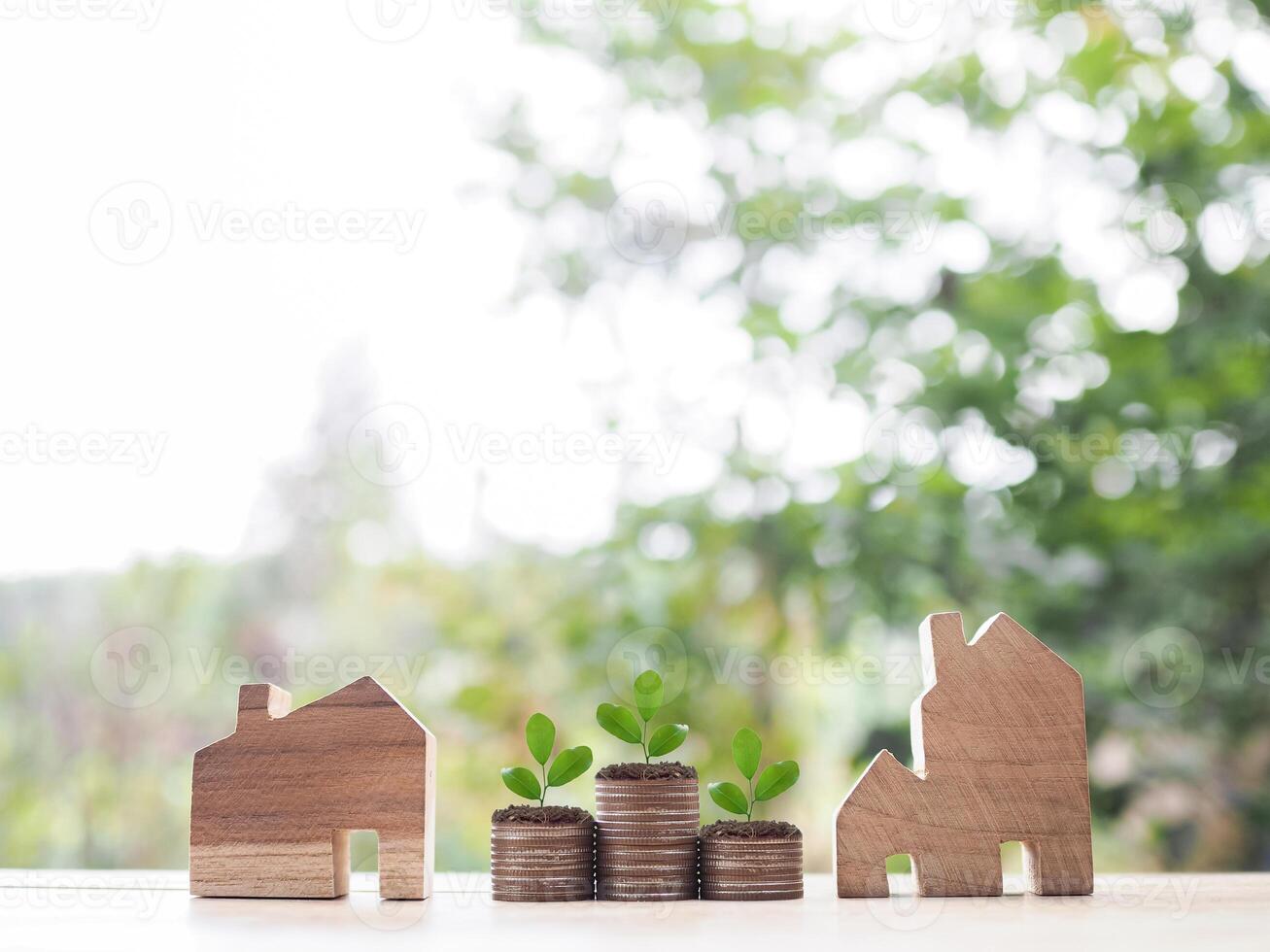 Miniature house and plants growing up on stack of coins. The concept of saving money for house, Property investment, House mortgage, Real estate. photo