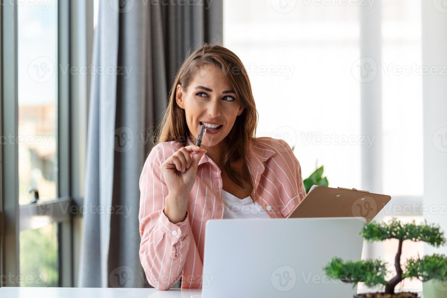 Remote job, technology and people concept - happy smiling young business woman with laptop computer and papers working at home office photo