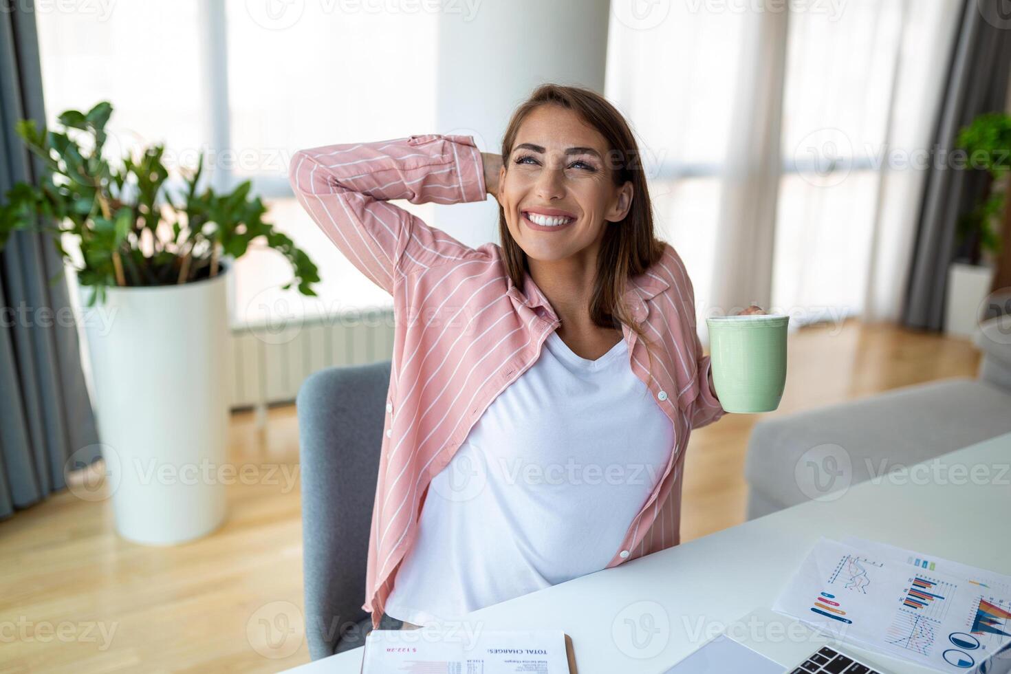 Young business women in the office drinking coffe and looking through a window photo