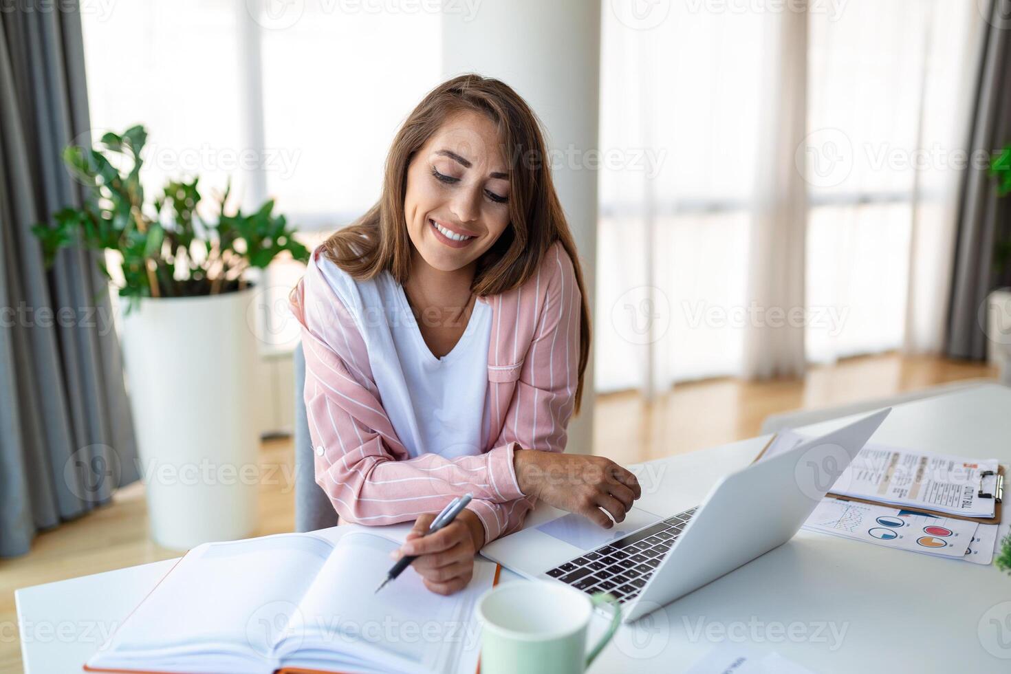 Young woman working laptop. Business woman busy working on laptop computer at office. Businesswoman sitting at bright modern work station and typing on laptop photo