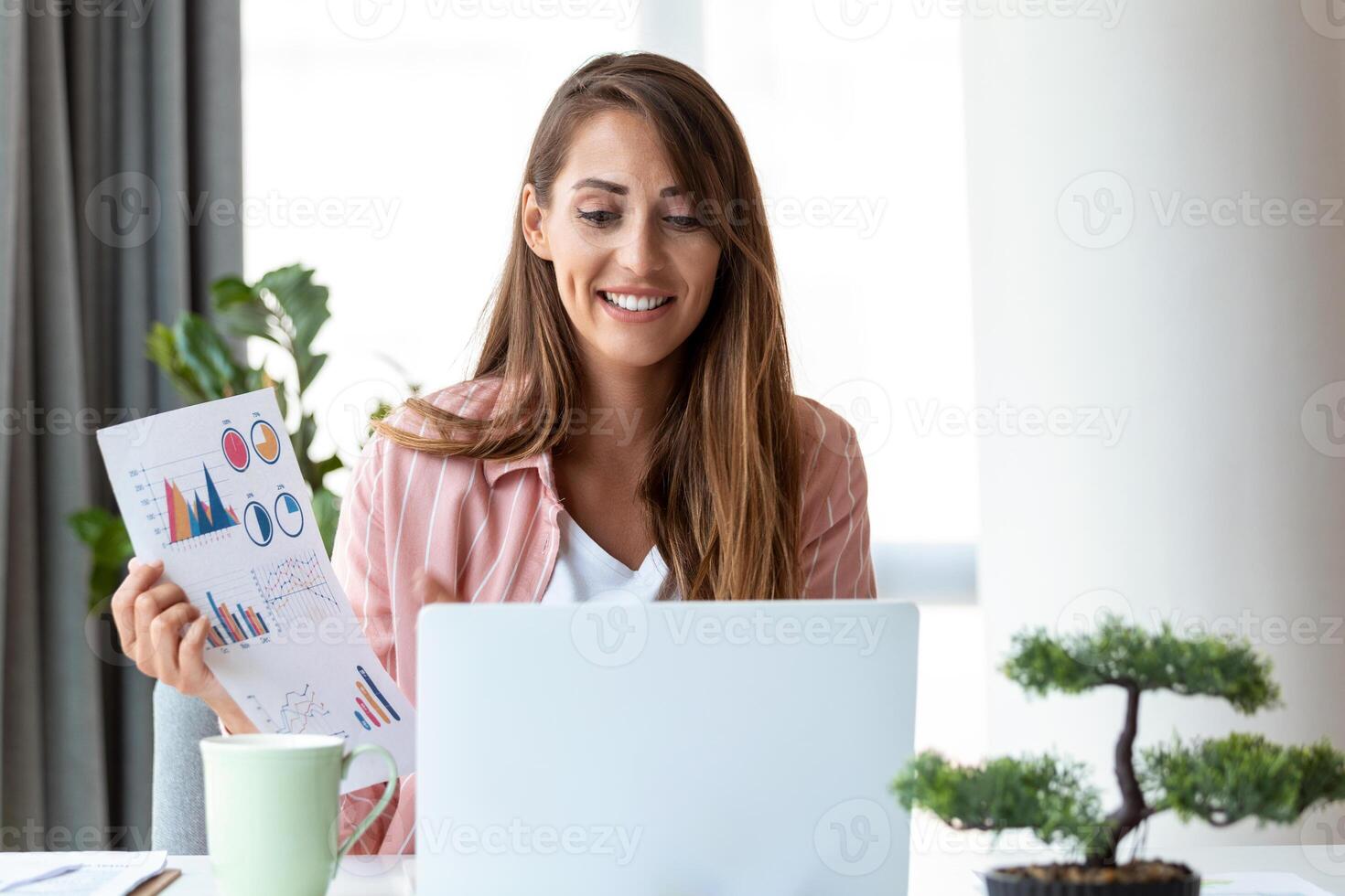 Remote job, technology and people concept - happy smiling young business woman with laptop computer and papers working at home office photo