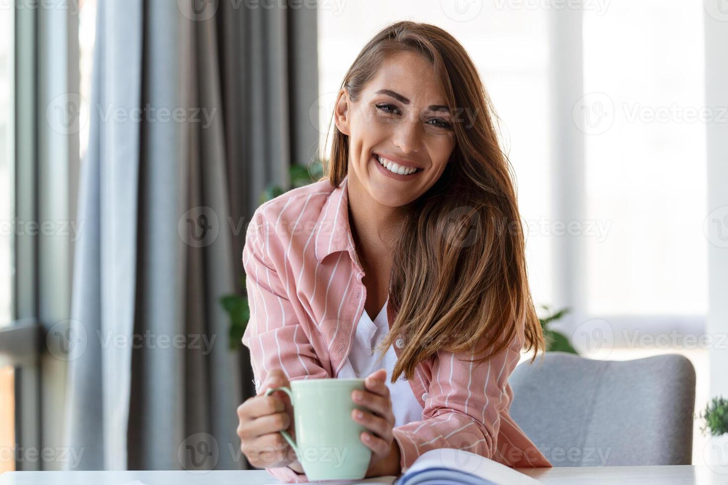 Young business women in the office drinking coffe and looking at the camera photo