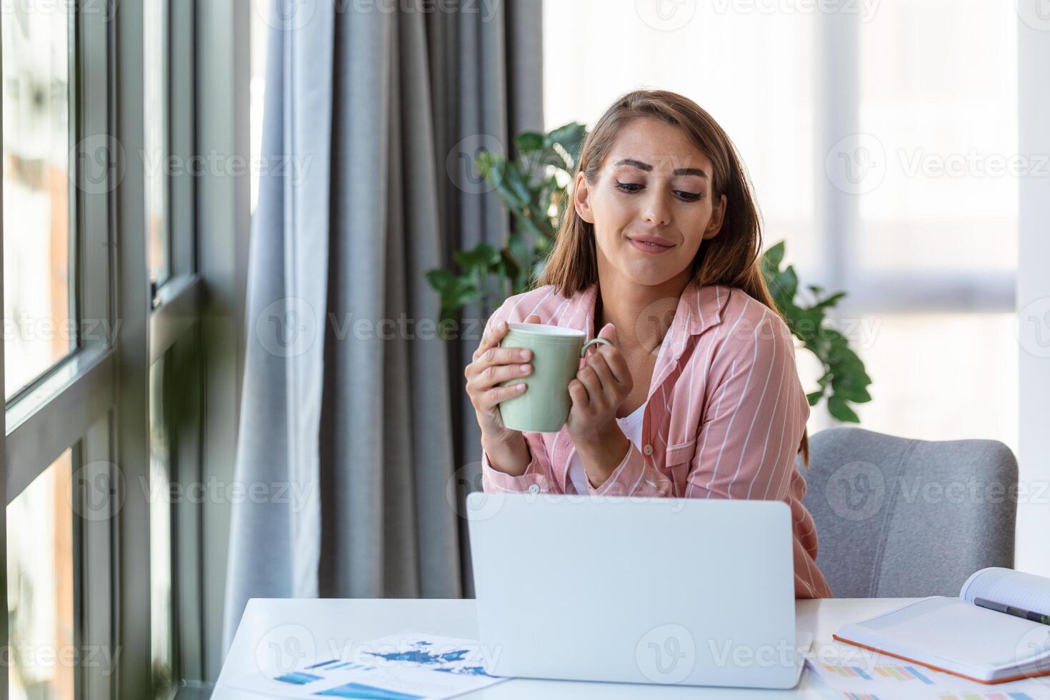 Remote job, technology and people concept - happy smiling young business woman with laptop computer and papers working at home office photo