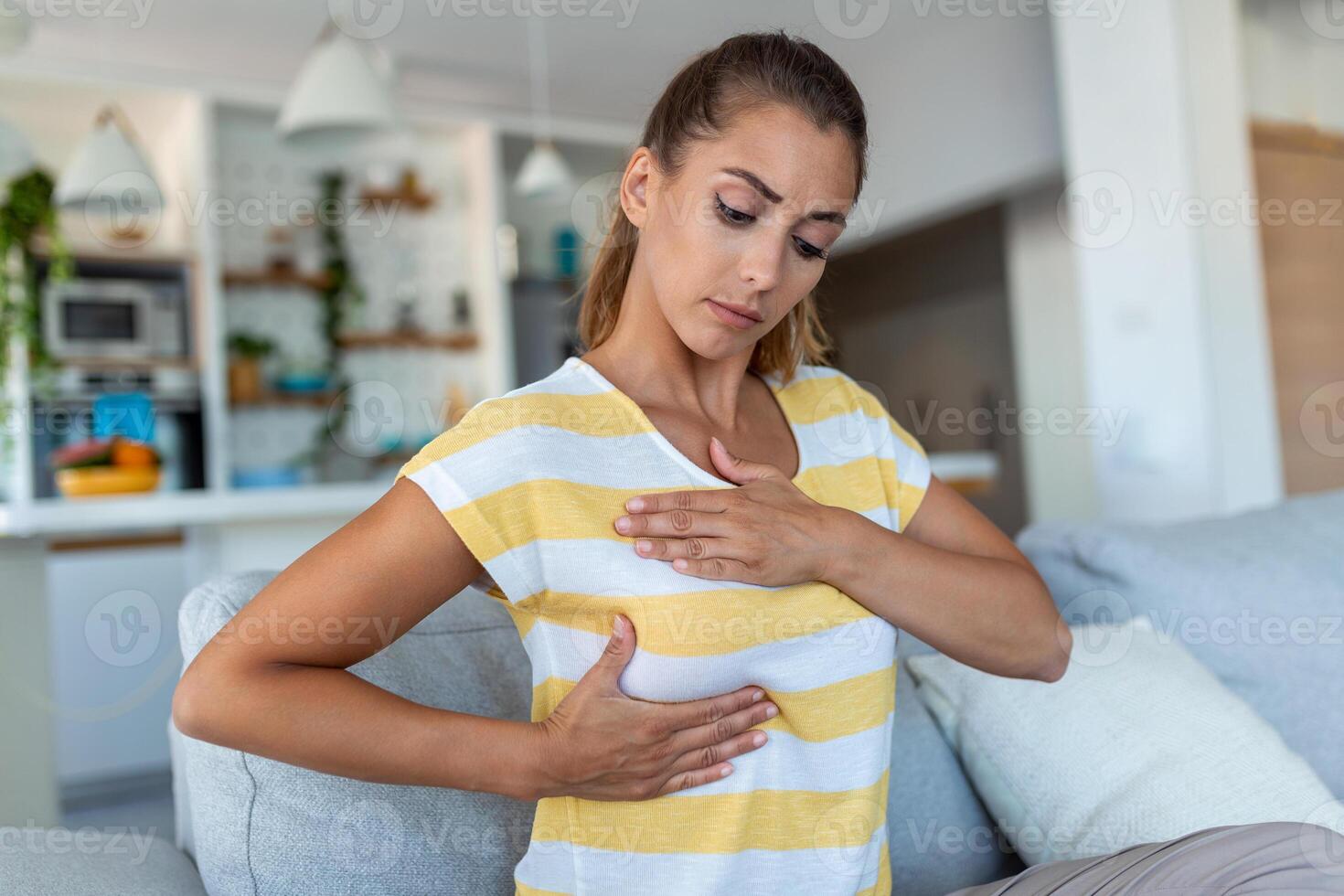 joven mujer caucásica palpando su pecho por sí misma que le preocupa el cáncer de mama. concepto de salud y cáncer de mama foto