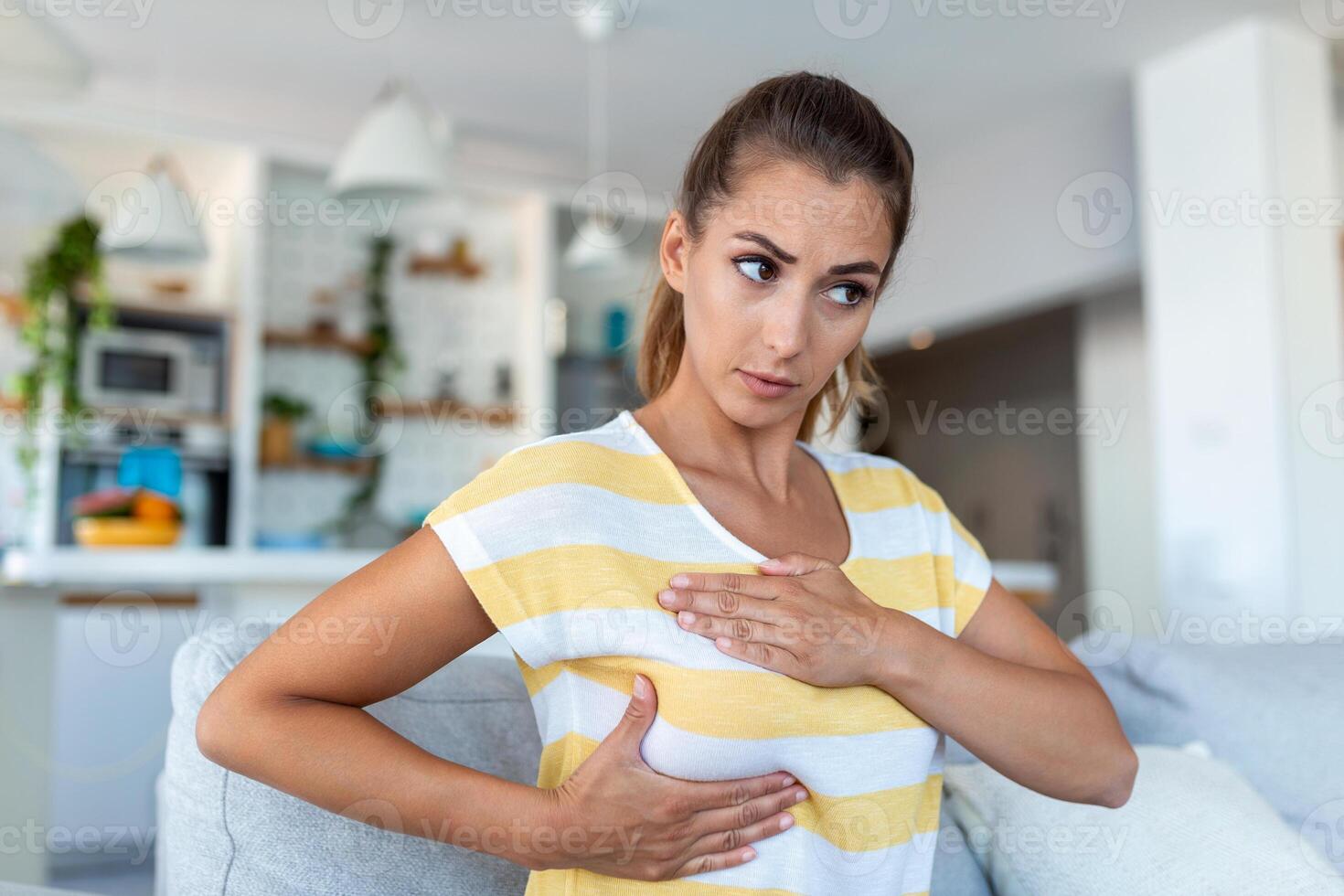 Young caucasian woman palpating her breast by herself that she concern about breast cancer. Healthcare and breast cancer concept photo