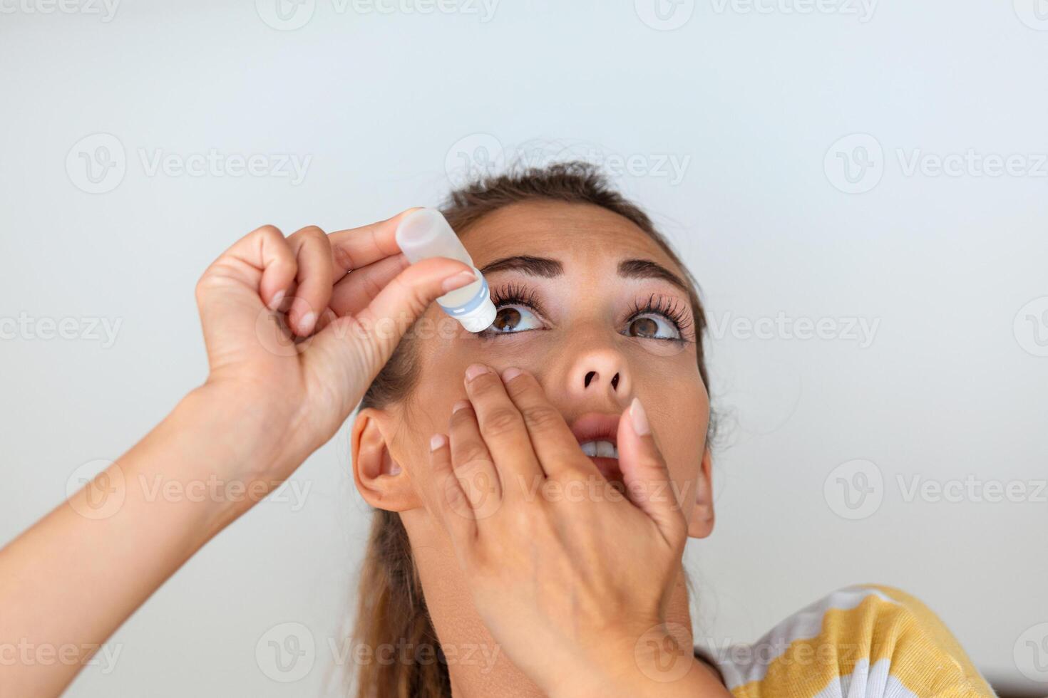 Woman using eye drop, woman dropping eye lubricant to treat dry eye or allergy, sick woman treating eyeball irritation or inflammation woman suffering from irritated eye, optical symptoms photo