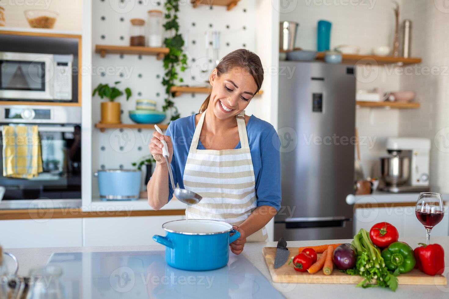 maravilloso joven dama en un moderno cocina, hábilmente cortar en cubitos vegetales a crear un Fresco vegetal ensalada destinado para almuerzo o cena. comprometido en hogar cocinando. foto