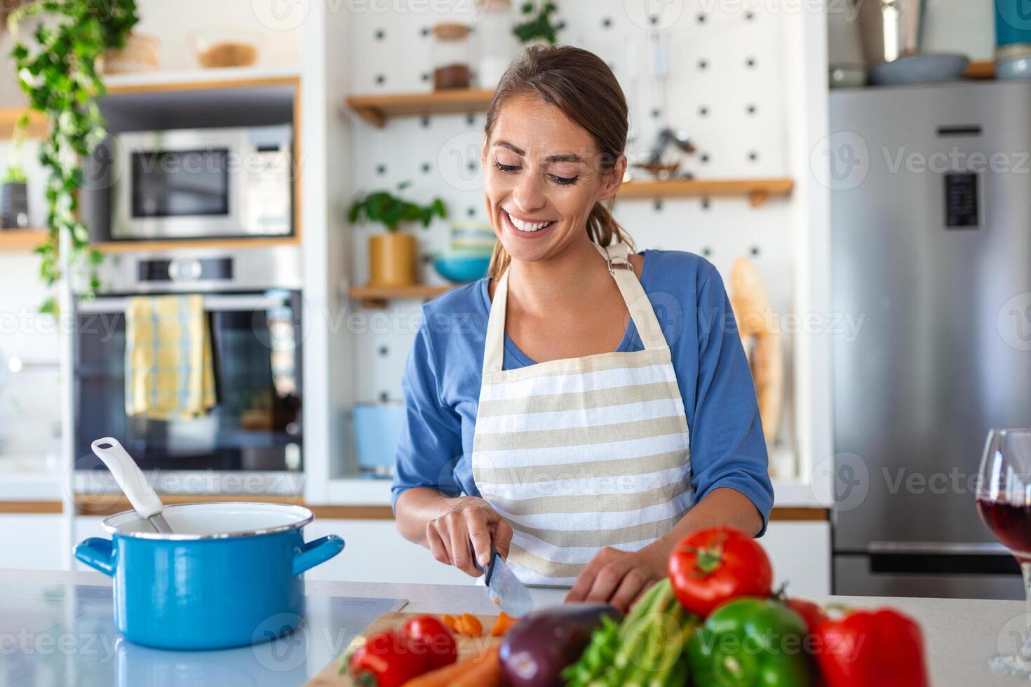 encantador joven dama en un contemporáneo cocina, rebanar vegetales a arte un Fresco vegetariano ensalada para almuerzo o cena. ella es Cocinando a su residencia, elaboración un nutritivo desayuno. foto