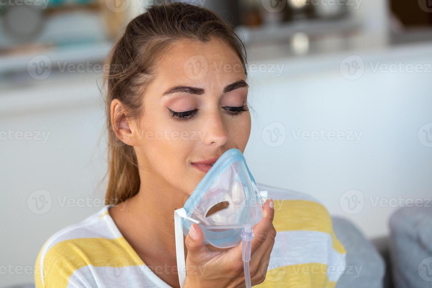 Sick woman making inhalation, medicine is the best medicine. Ill woman wearing an oxygen mask and undergoing treatment for covid-19. woman with an inhaler photo