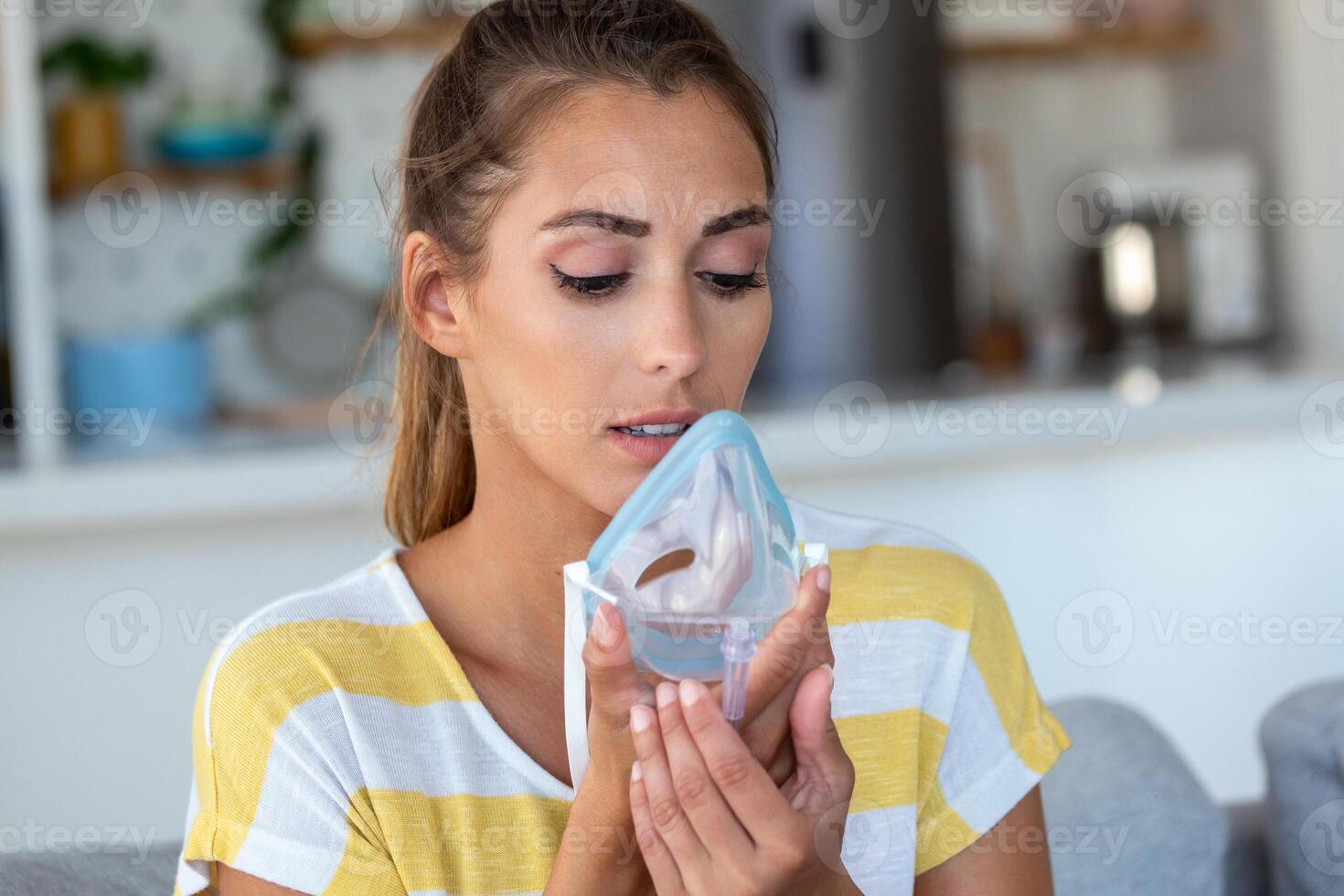 Sick woman making inhalation, medicine is the best medicine. Ill woman wearing an oxygen mask and undergoing treatment for covid-19. woman with an inhaler photo