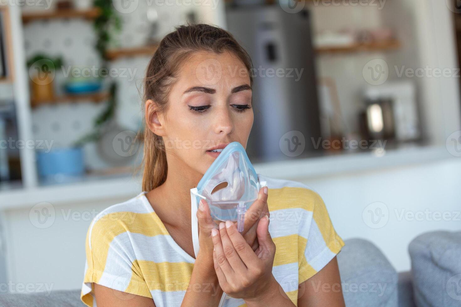 Sick woman making inhalation, medicine is the best medicine. Ill woman wearing an oxygen mask and undergoing treatment for covid-19. woman with an inhaler photo