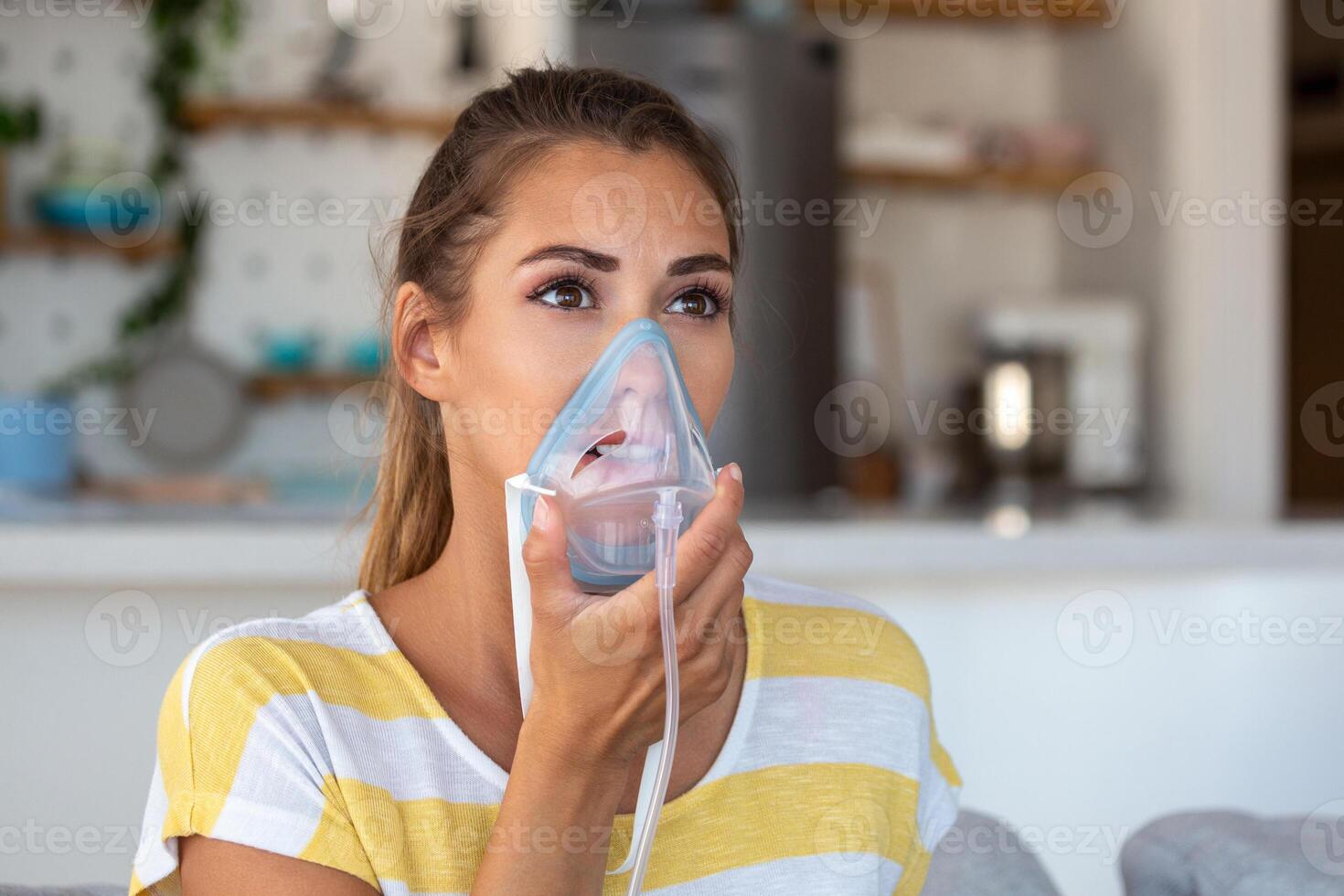 Sick woman making inhalation, medicine is the best medicine. Ill woman wearing an oxygen mask and undergoing treatment for covid-19. woman with an inhaler photo