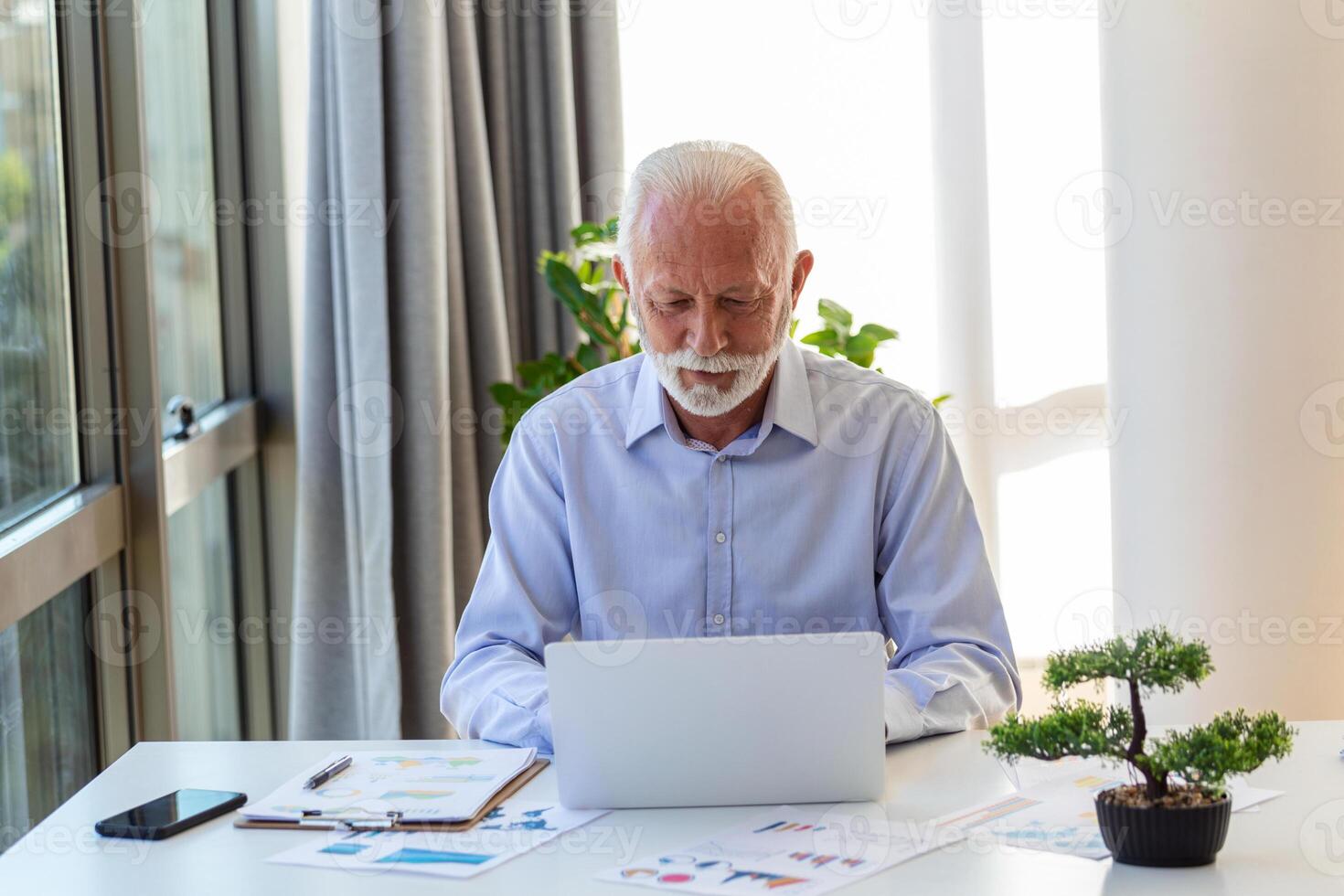 financiero tutor empresario utilizando su ordenador portátil y haciendo algunos papeleo mientras sentado a escritorio y laboral. foto