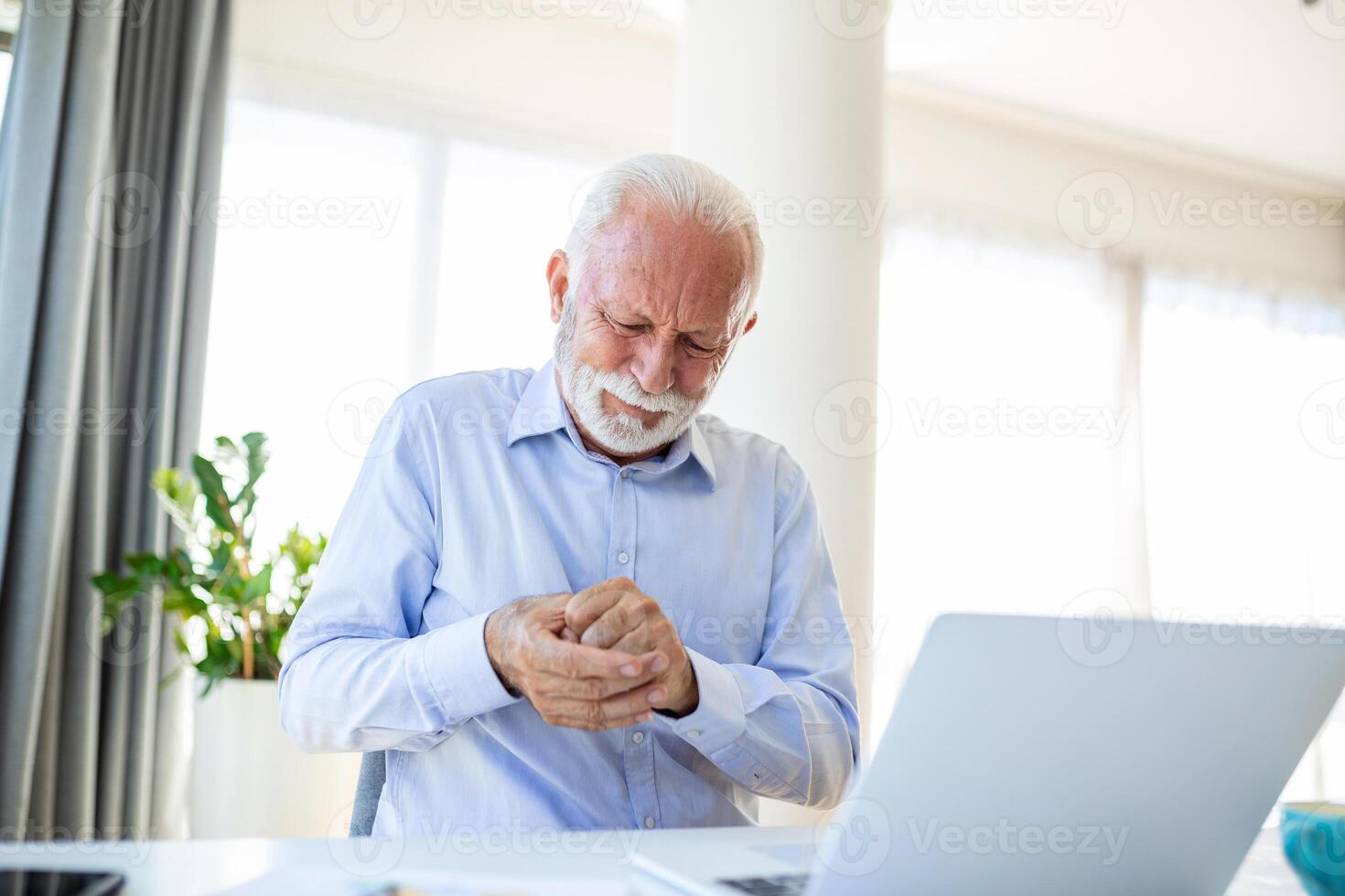 Elderly man has pain in fingers and hands. Old man with finger pain, Man massaging his arthritic hand and wrist. photo